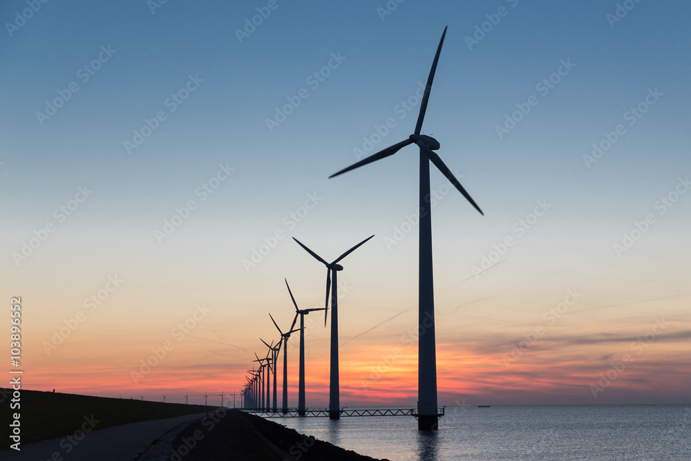 美丽日落下的荷兰式海上风力涡轮机