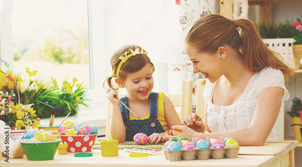快乐家庭母亲和小女孩为复活节画彩蛋