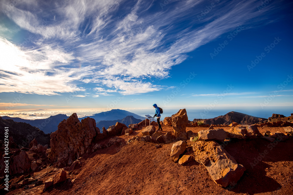 一名身穿蓝色夹克和背包的女子在La Palmas岛Andenes视点附近的山区旅行
