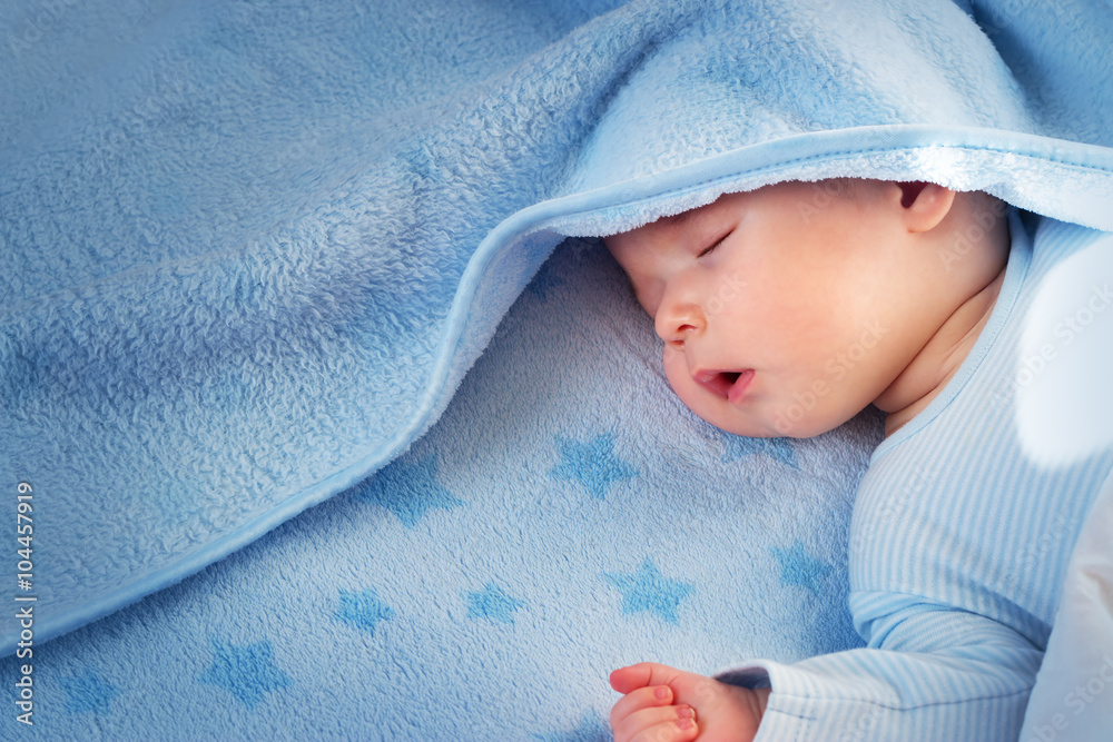三个月大的婴儿睡在蓝色毯子上