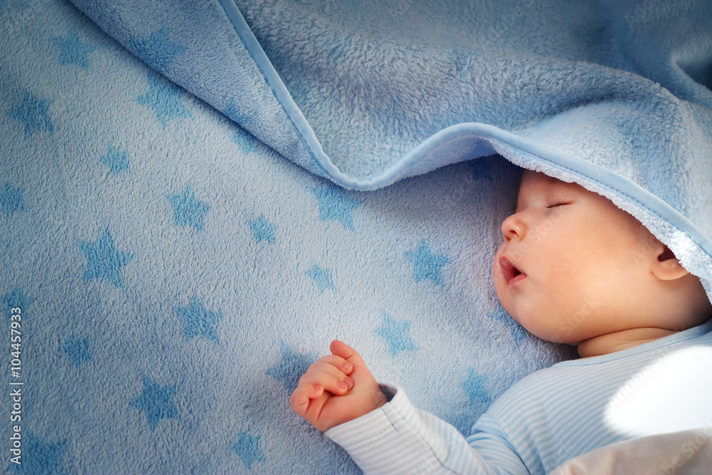 三个月大的婴儿睡在蓝色毯子上