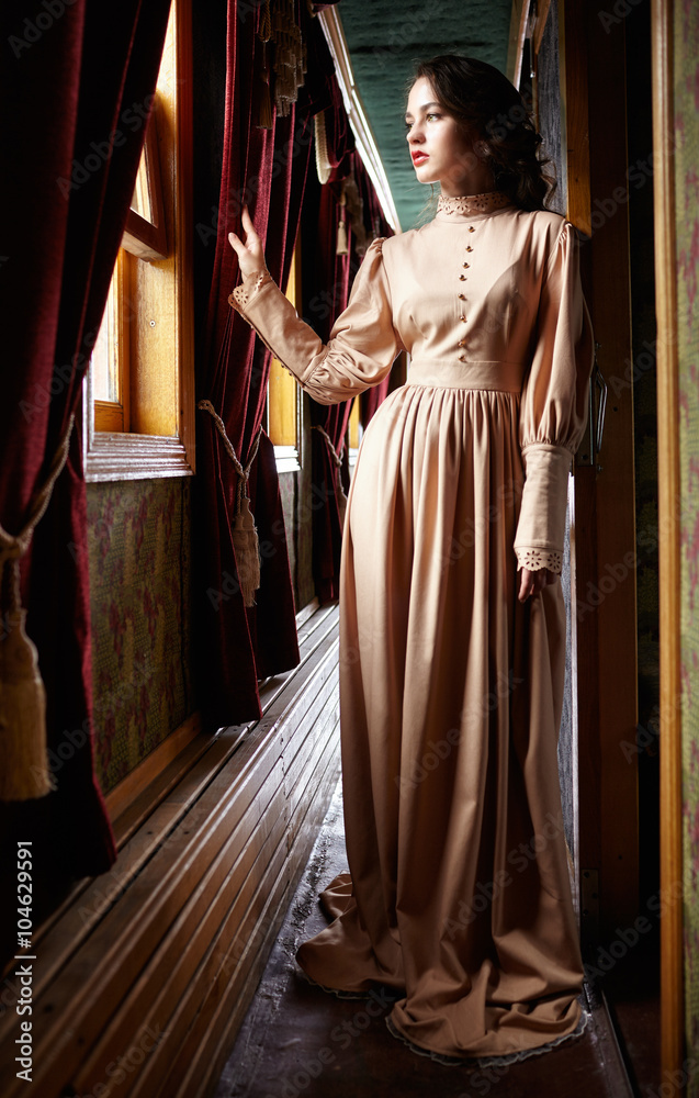 穿着20世纪初米色复古连衣裙的年轻女性
