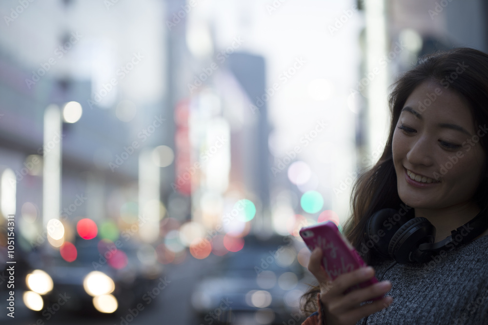 年轻女性在现代城市使用智能手机