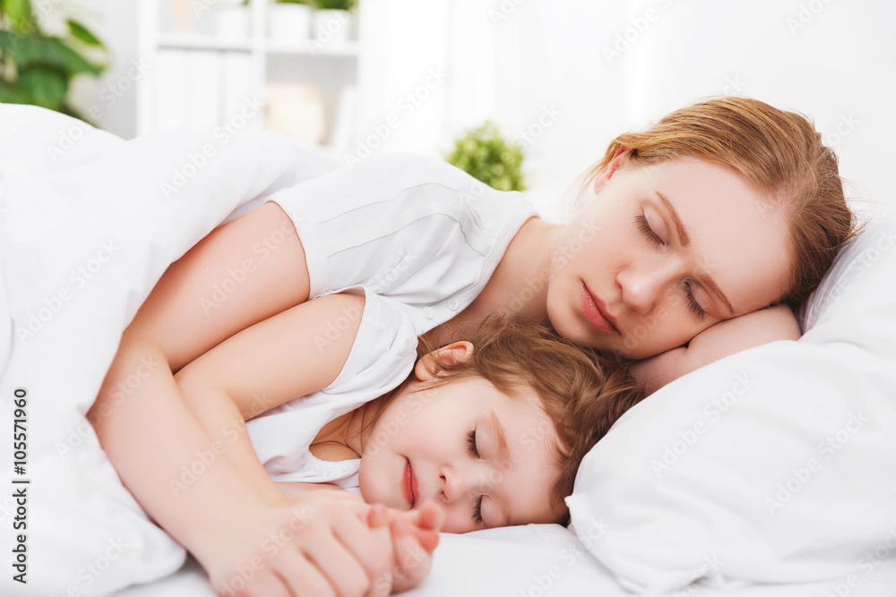 happy family mother and child sleeping in bed