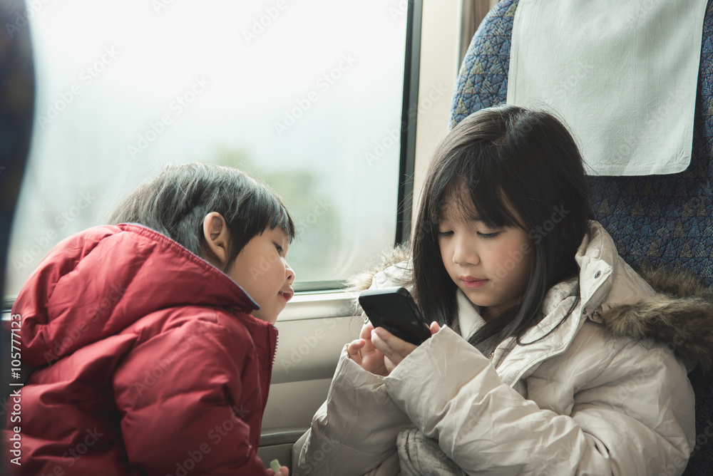 亚洲孩子一起玩手机游戏，