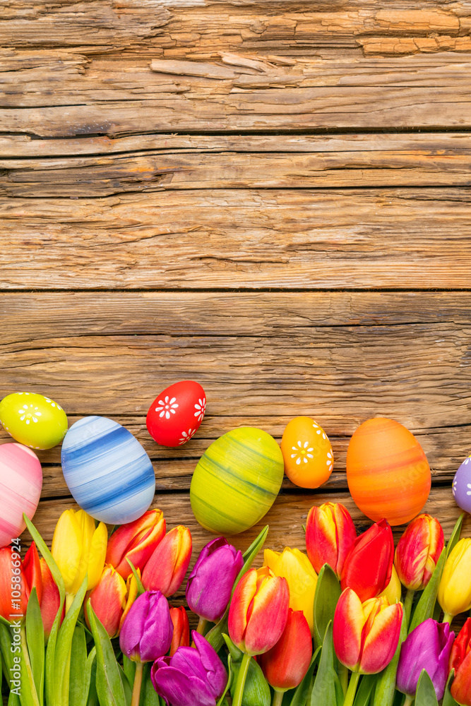 木制背景的复活节彩蛋和郁金香