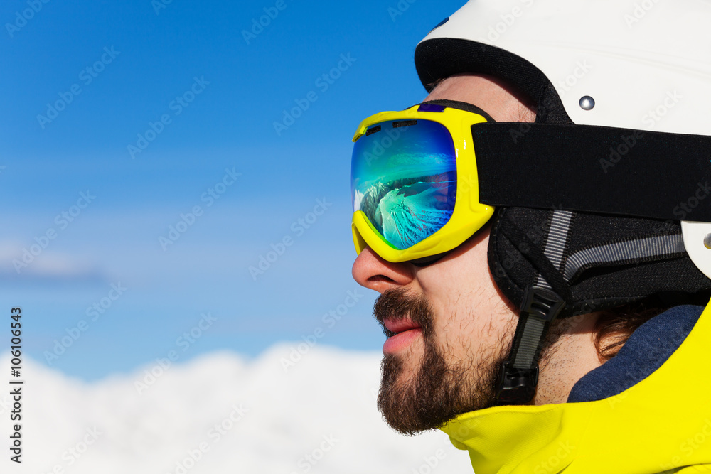 Close portrait of man in ski mask over mountains