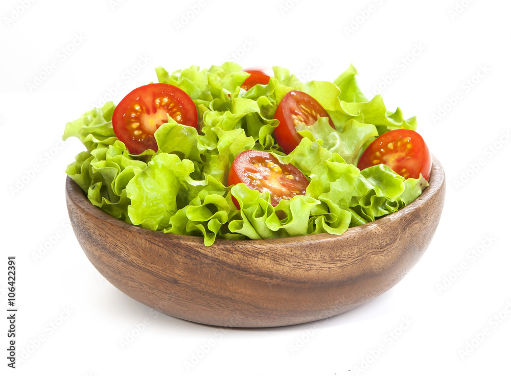 Tomato and lettuce in wooden bowl isolated on white background