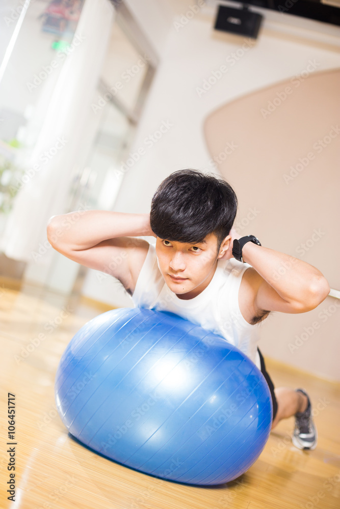 年轻英俊的亚洲男子在现代健身房锻炼