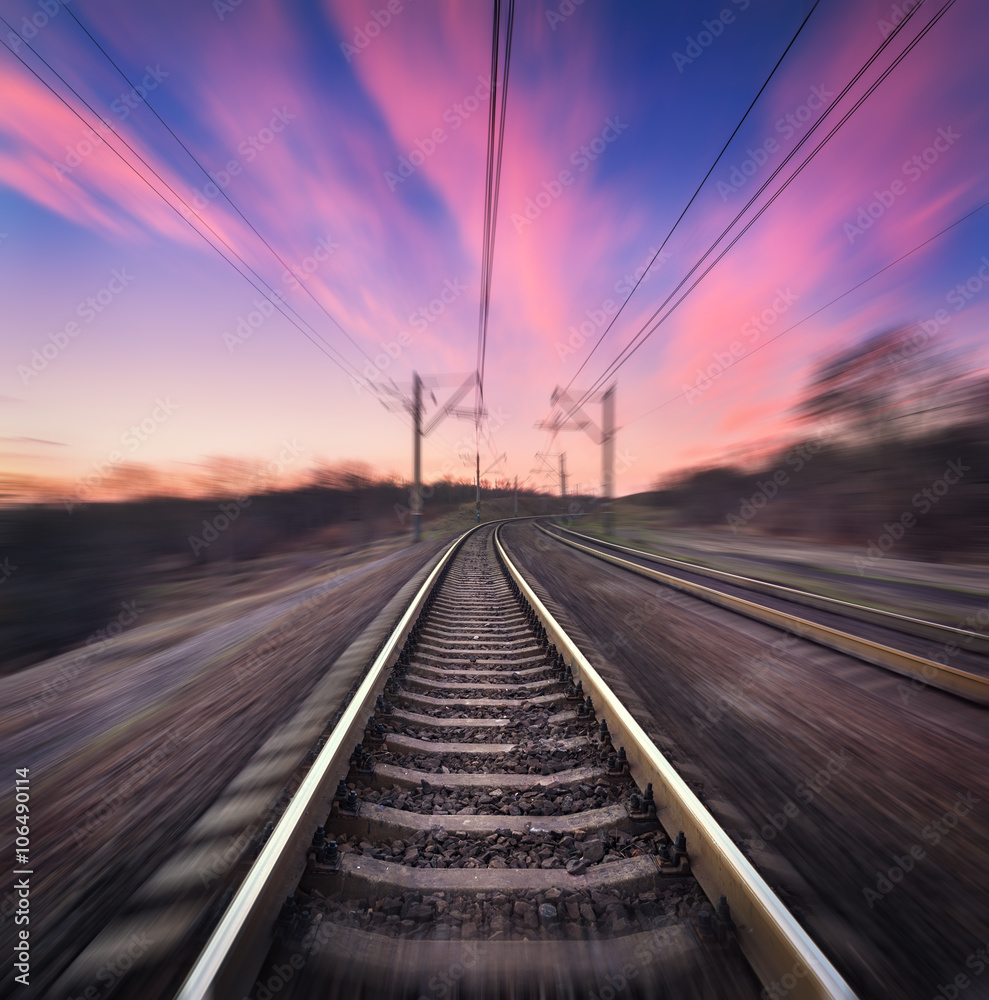 彩色日落下蓝天背景下的火车站，具有运动模糊效果。铁路i