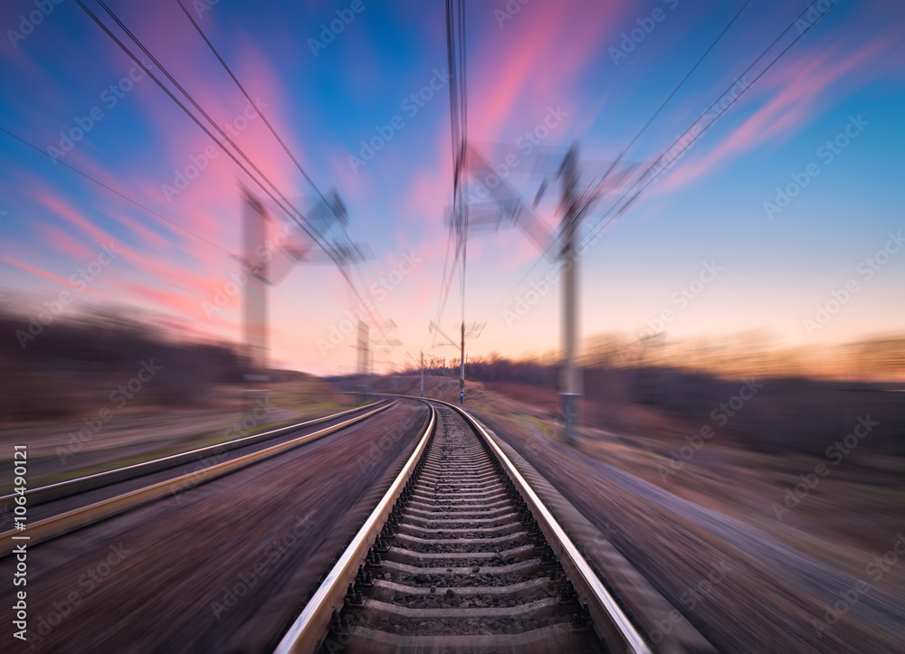 Railway station on the background of blue sky at colorful sunset with motion blur effect. Railroad i