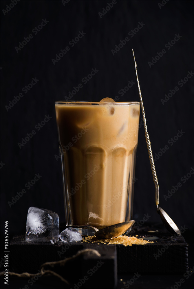 高玻璃杯中的冰咖啡加牛奶，黑色背景