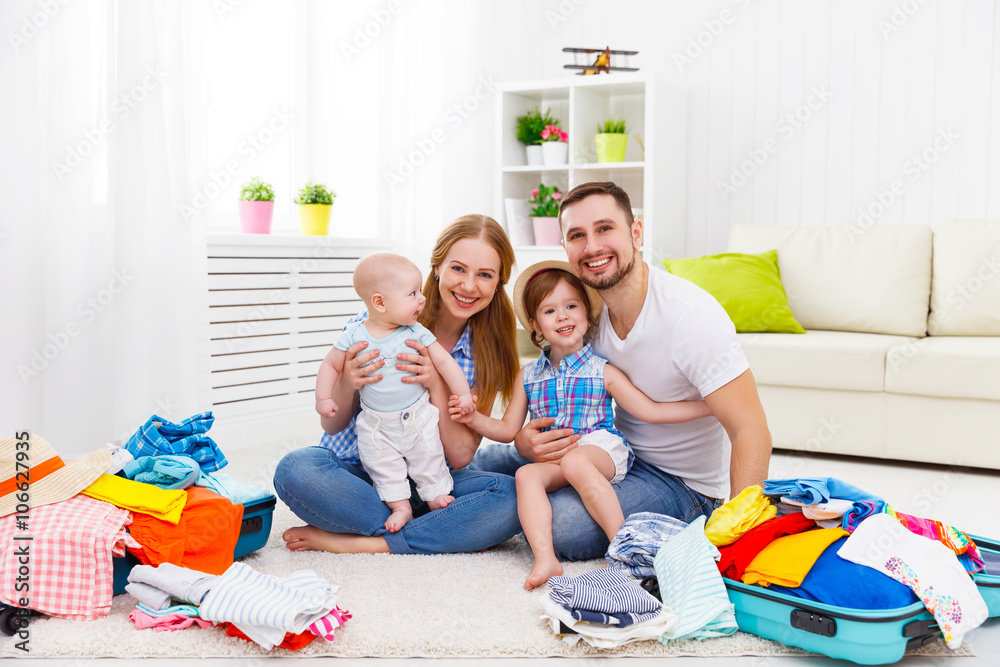 幸福的家庭母亲、父亲和两个孩子收拾行李箱