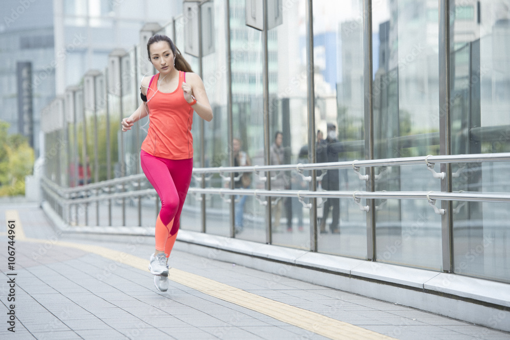 亚洲女性带智能手表慢跑