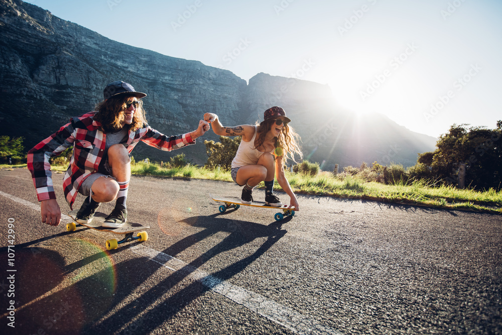 情侣在路上玩滑板玩得很开心