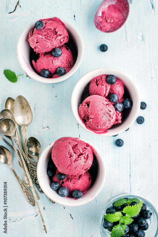 自制蓝莓冰淇淋勺，杯装新鲜浆果和薄荷叶，浅蓝色背面