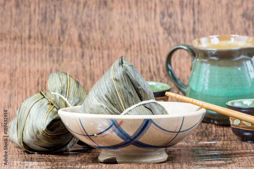 Zongzi or sticky rice dumpling (Chinese Rice Dumplings food) with teapot for dragon boat festival