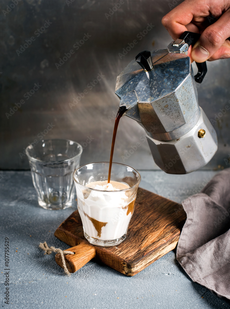 一杯咖啡配冰淇淋，放在乡村木板上。饮料是用意大利莫卡钢壶倒的。