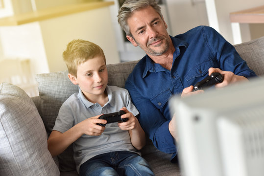 Father and son playing video game on tv
