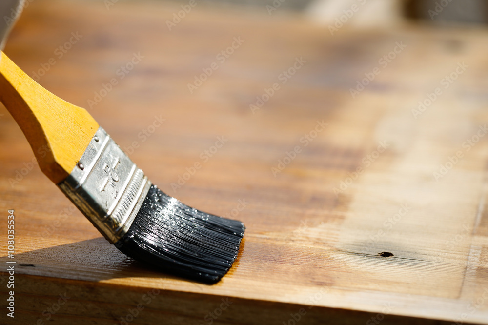 画笔在木制表面滑动，保护木材