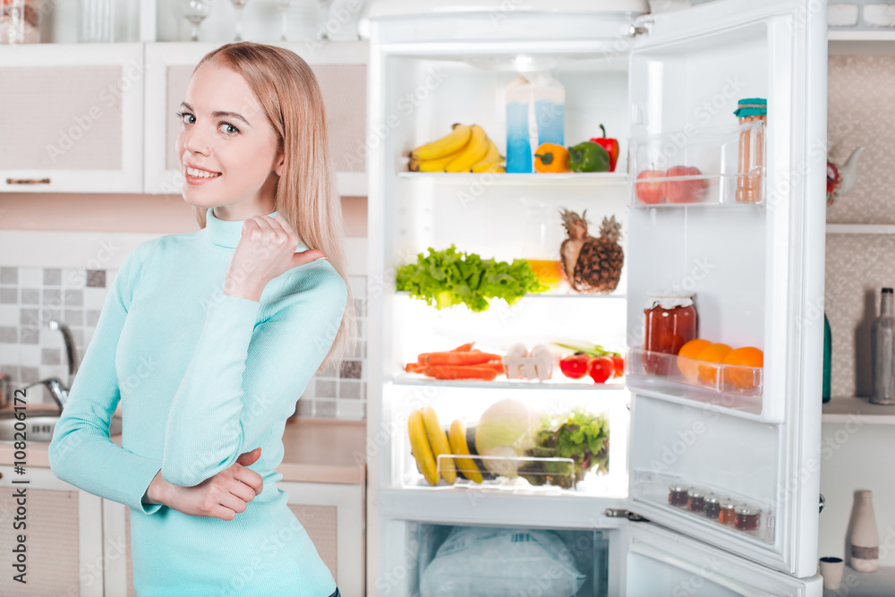 Young blonde at home near fridge