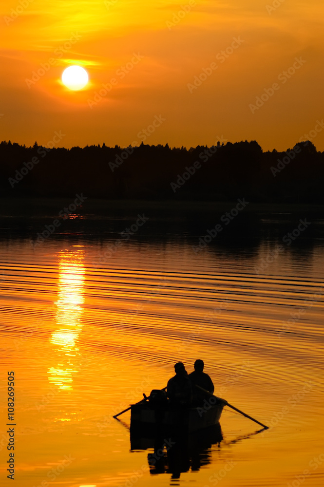 日落时渔民在船上的剪影