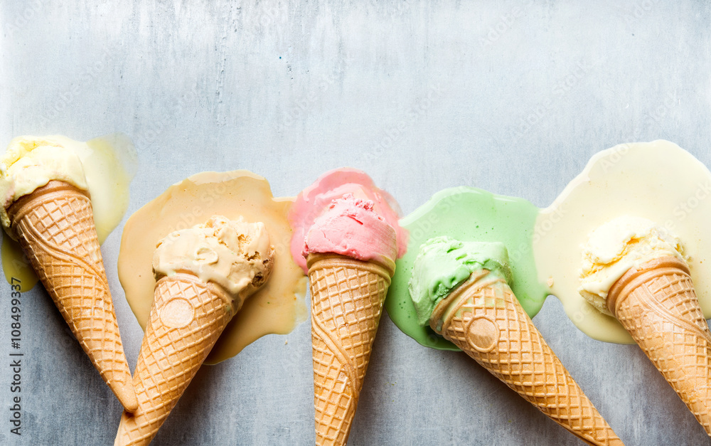Colorful ice cream cones of different flavors. Melting scoops. Top view,  steel metal background