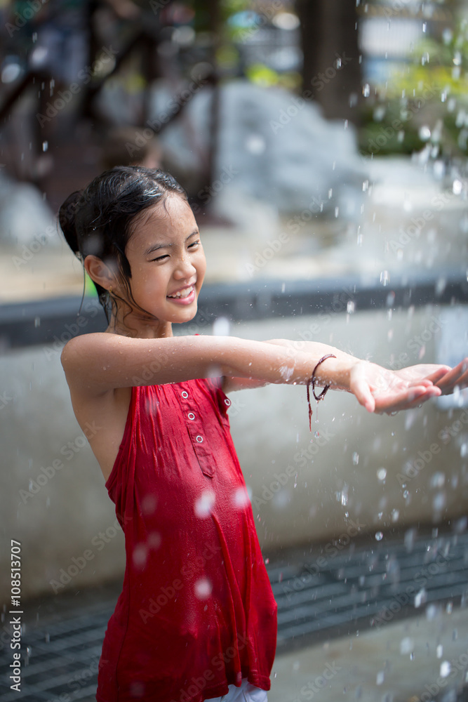 亚洲女孩在水上公园玩喷泉