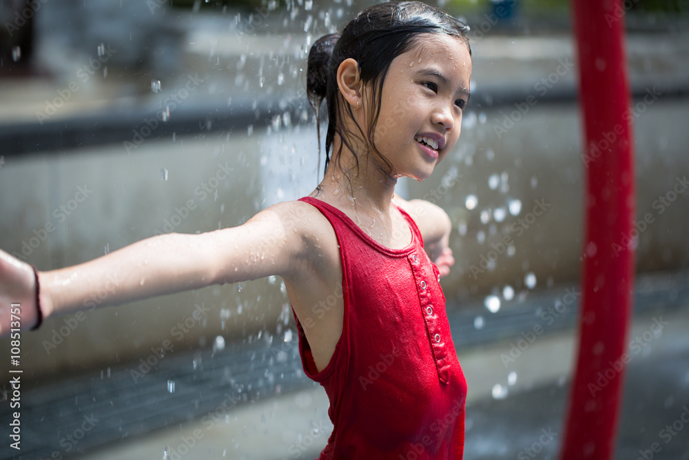 亚洲女孩在水上公园玩喷泉