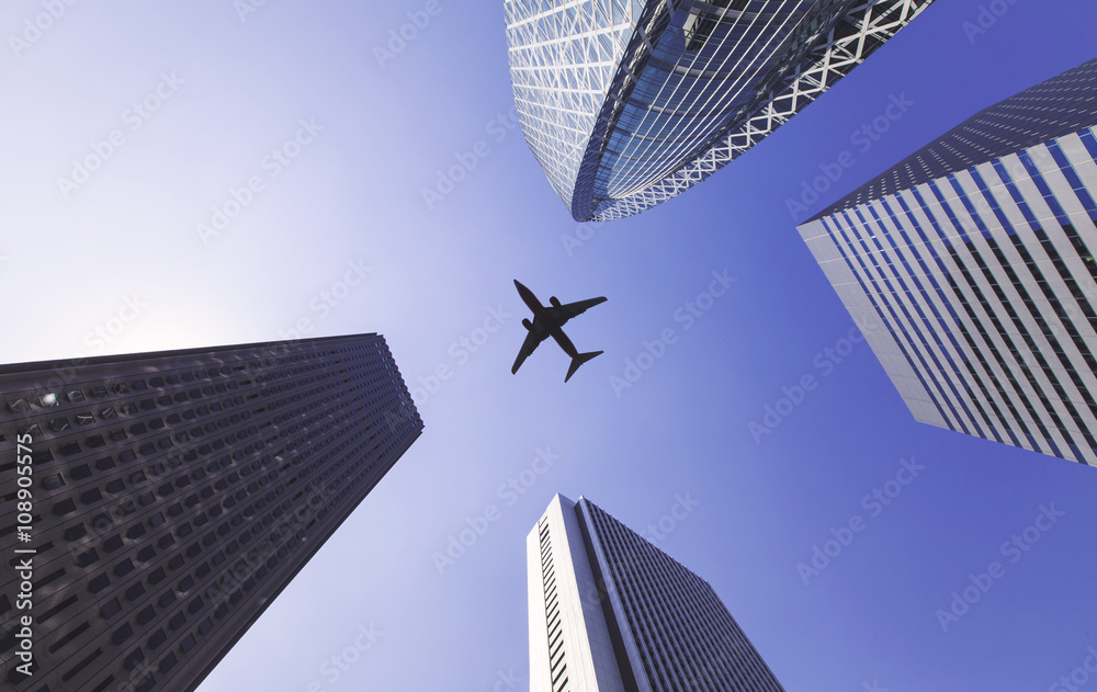 飞机在高大的城市建筑之间飞行