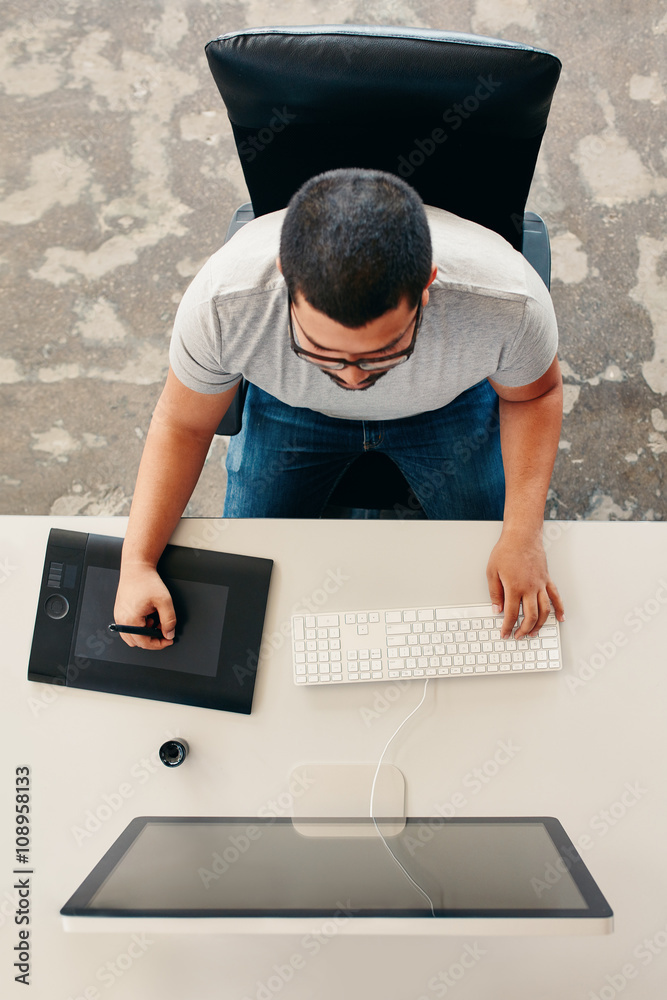 Designer using digital graphics tablet and desktop