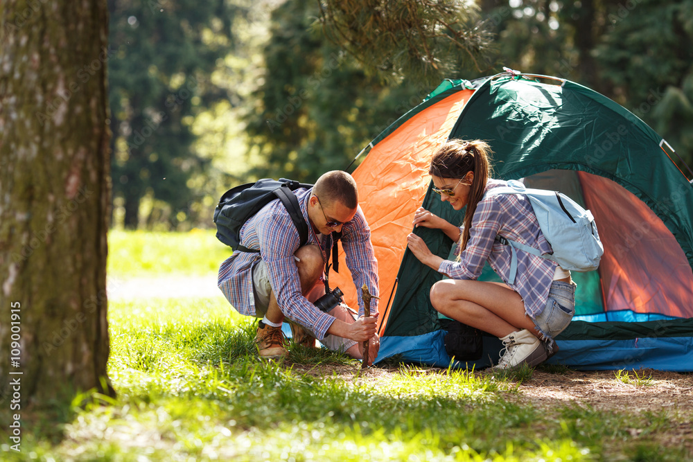 年轻的露营者在森林里搭建帐篷。