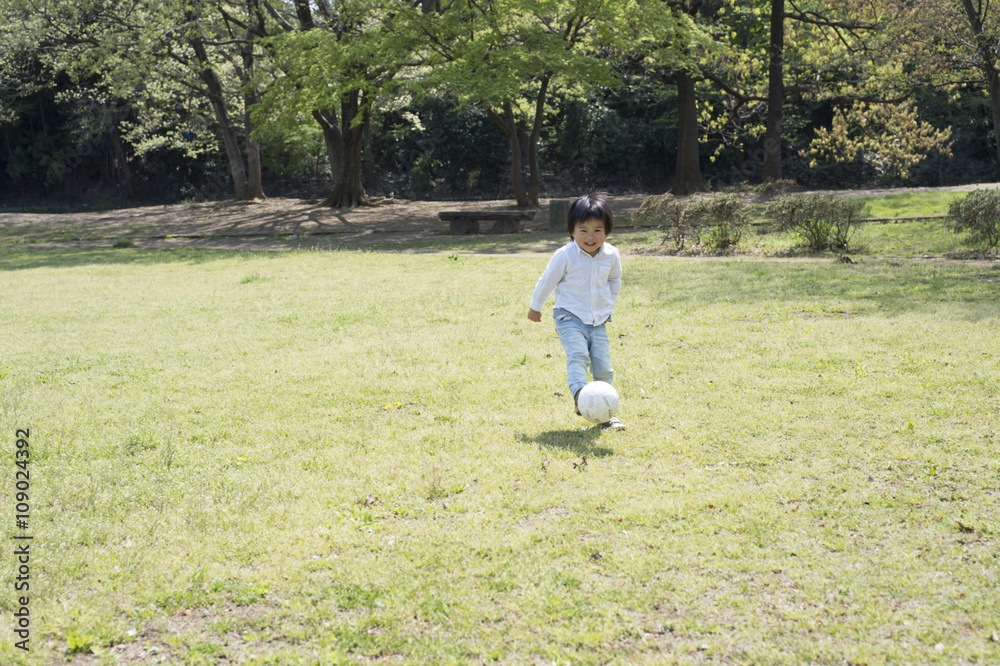 小男孩在公园里踢足球