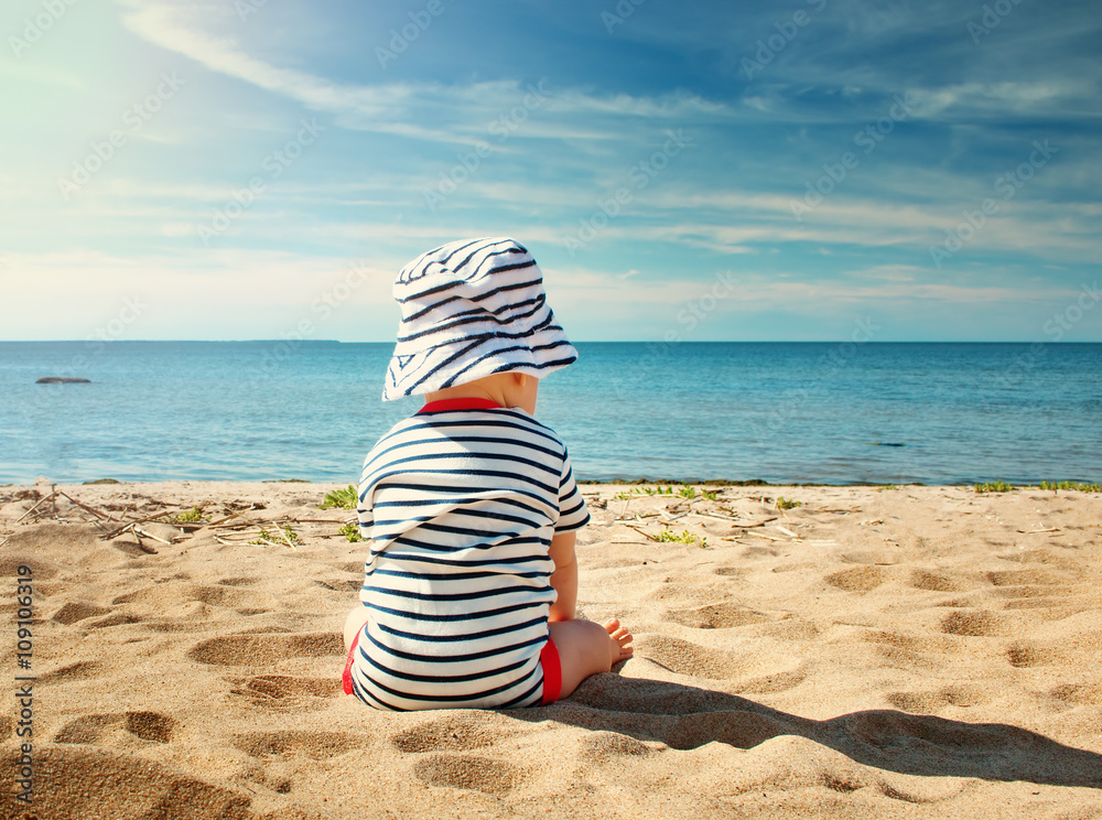 夏日坐在海滩上的小男婴