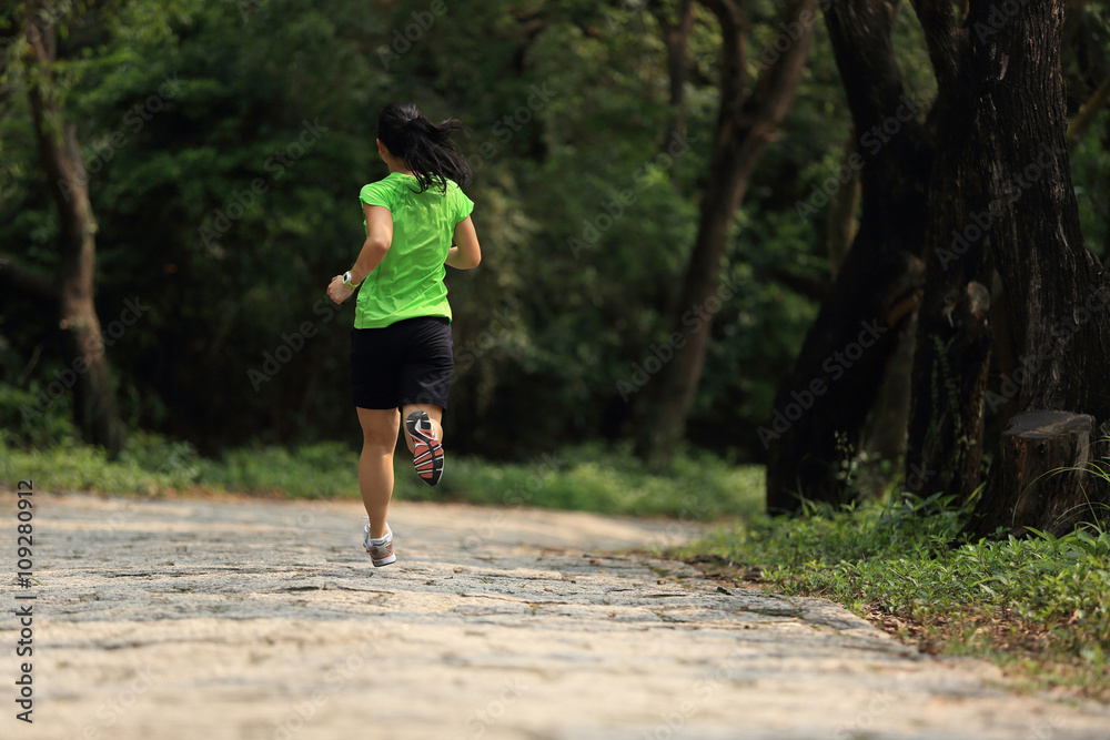 跑步运动员在森林小径上跑步。女性健身慢跑锻炼健康理念。