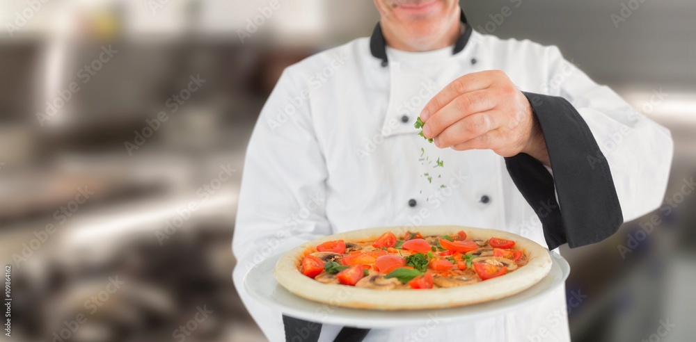 Composite image of portrait of a chef holding a pizza and adding