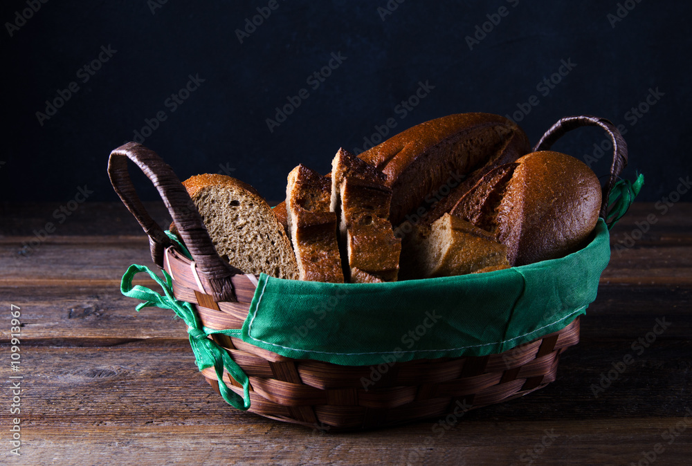 黑麦面包，放在木桌上的篮子里的法棍面包