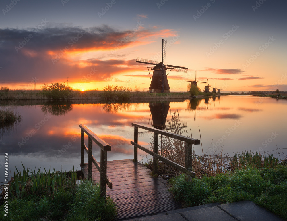 蓝天白云的运河附近有美丽的传统荷兰风车的景观