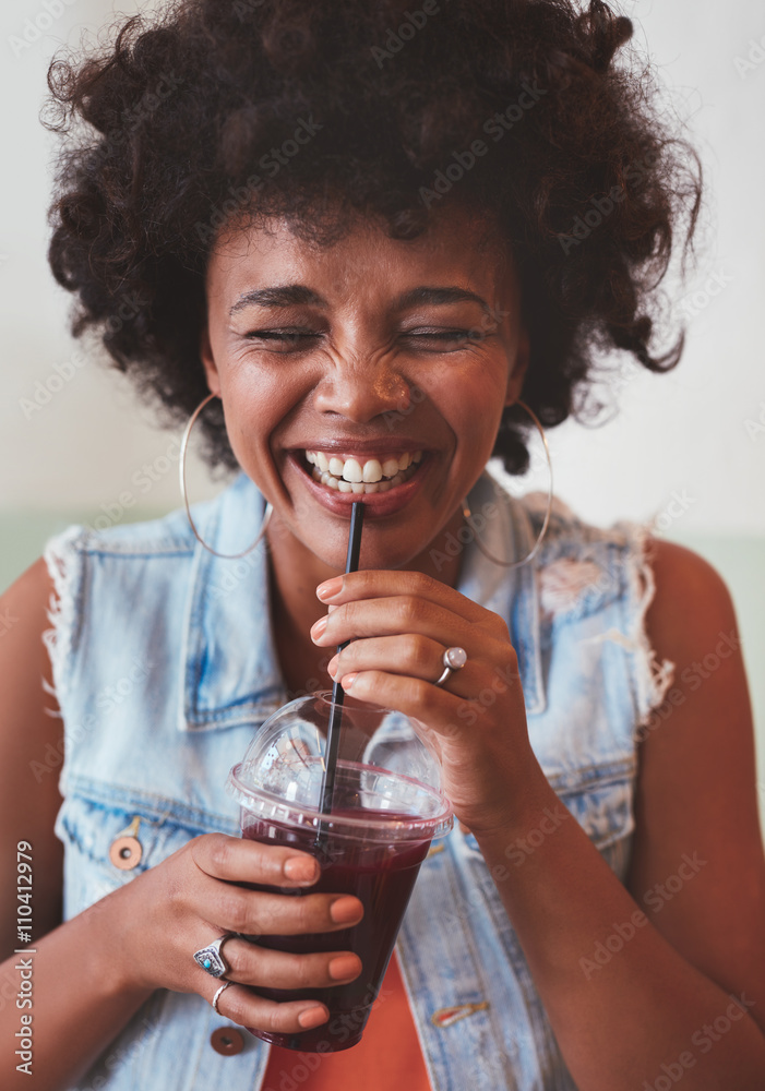 Happy young woman enjoying fresh fruit juice
