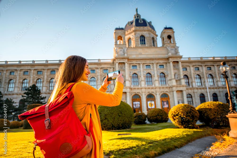 年轻女性游客用智能手机拍摄维也纳艺术史博物馆。