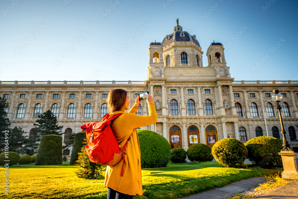 年轻女性游客用智能手机拍摄维也纳艺术史博物馆。