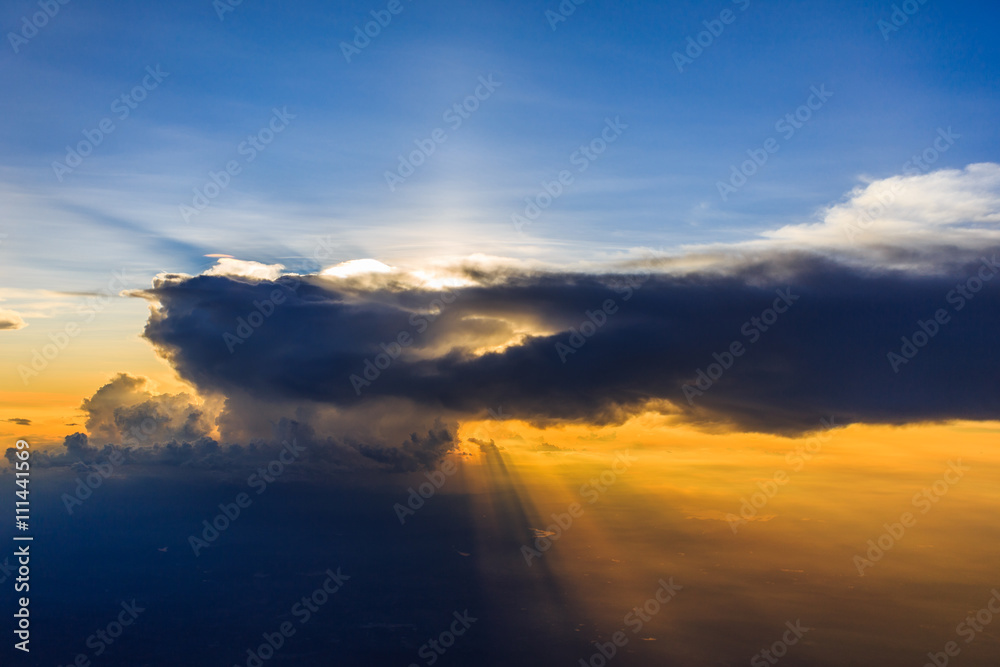 light beam of sunlight through clouds above sunset sky