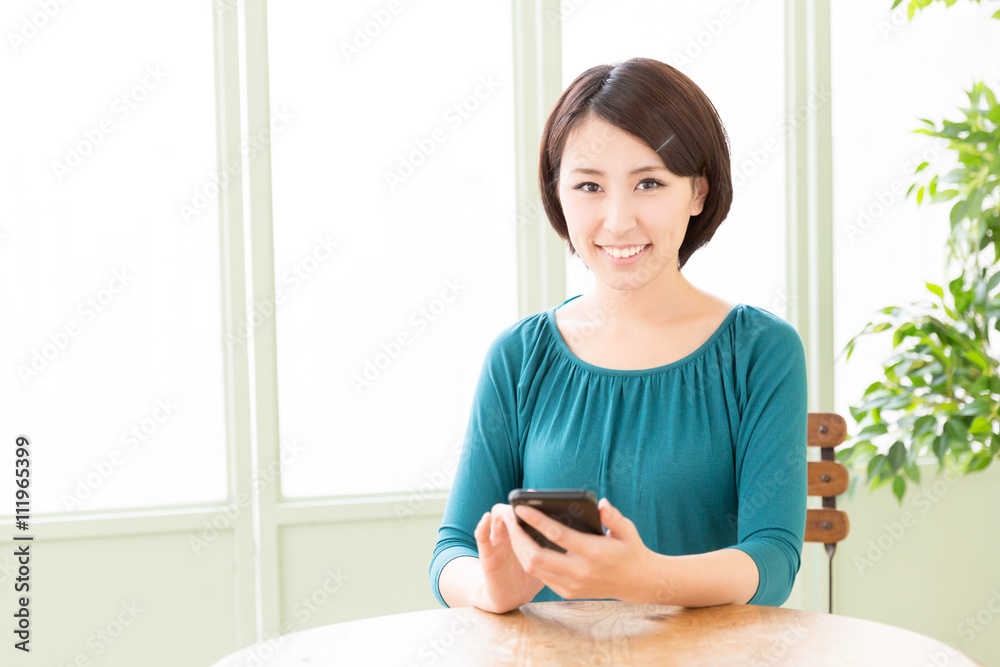 年轻的亚洲女人在咖啡馆使用智能手机