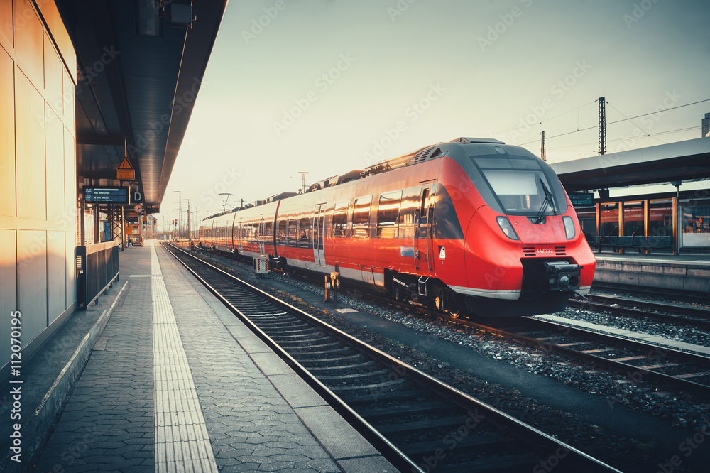 德国纽伦堡美丽的火车站，在五彩缤纷的日落下，有现代化的红色通勤列车。R