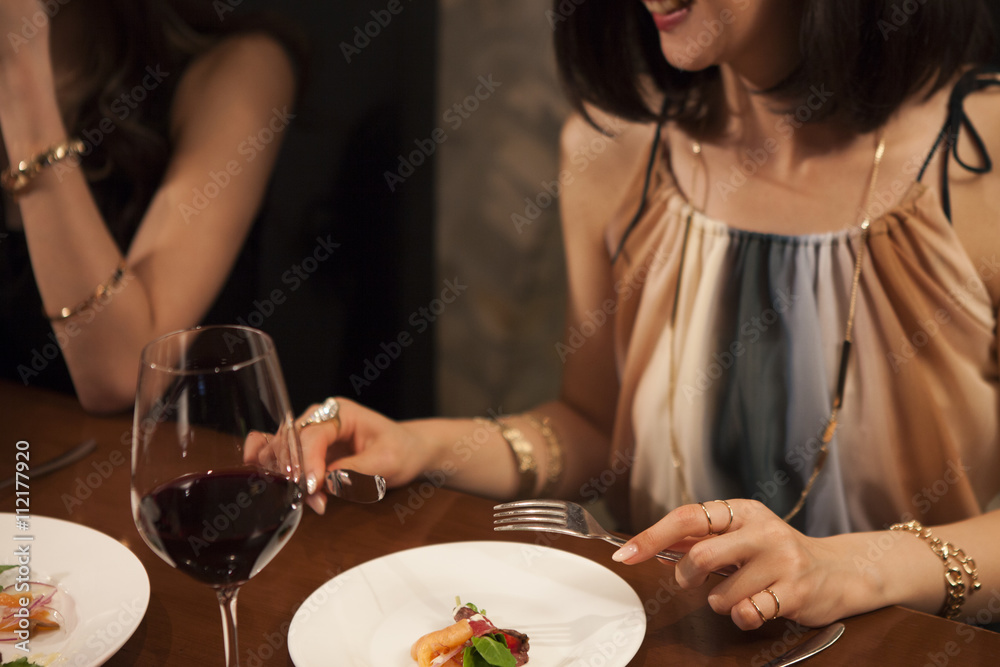 Young women have a meal with a cup of red wine
