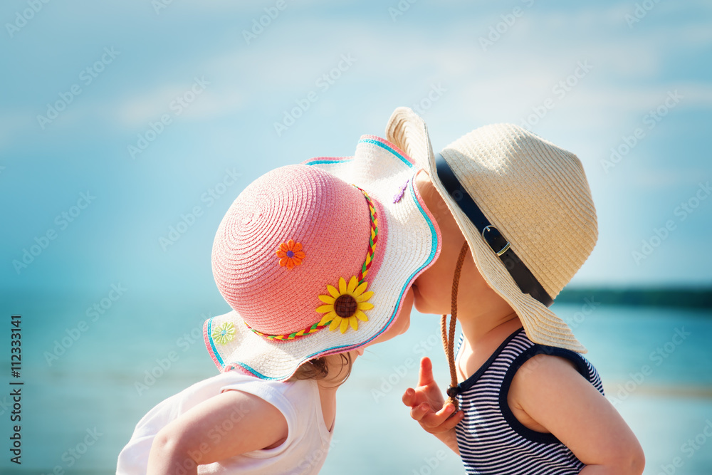 女婴和男婴在海滩上接吻