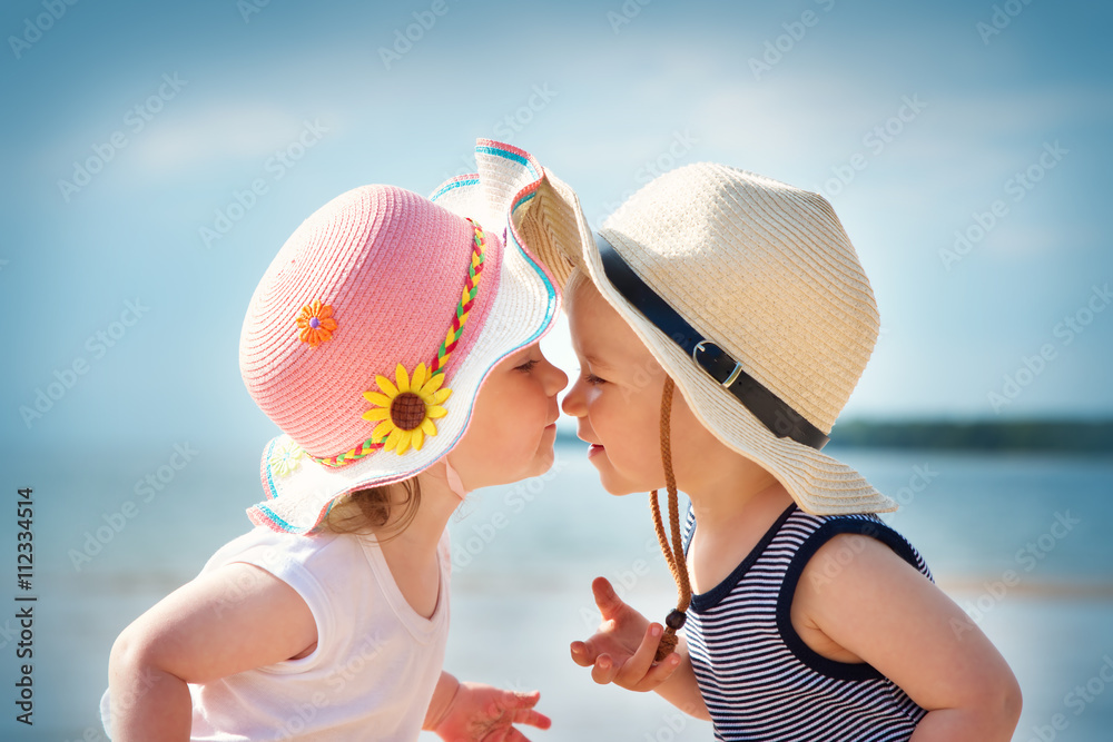 女婴和男婴在海滩上接吻
