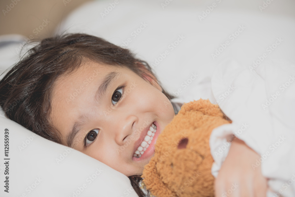 Smiling little girl with a teddy bear