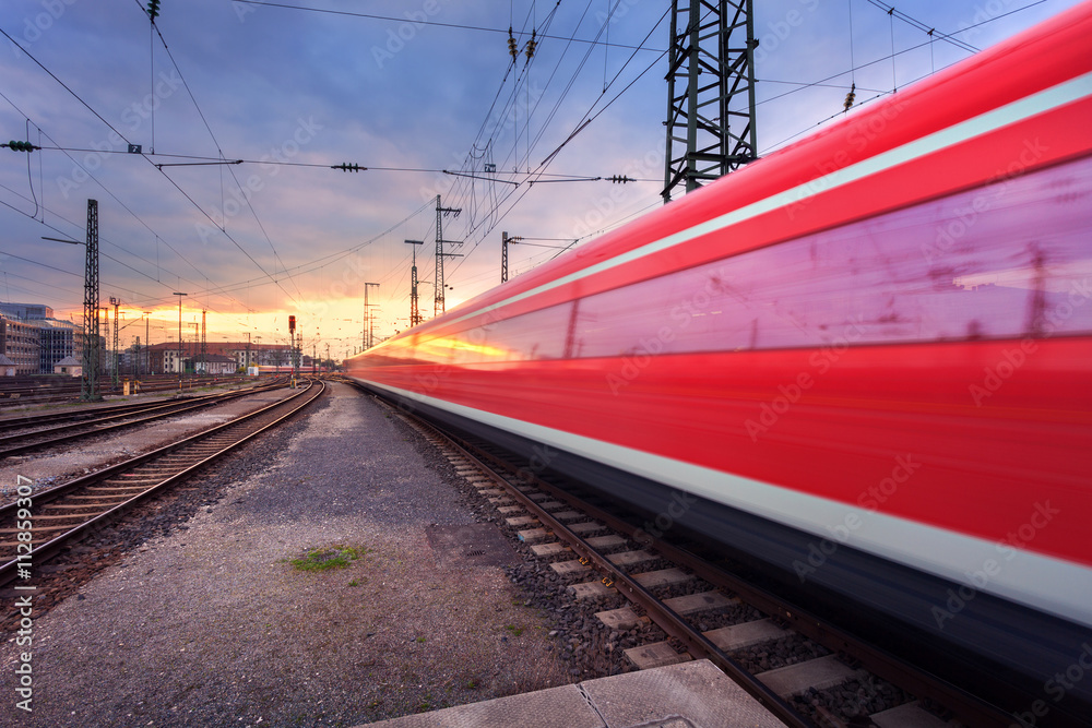 日落时分，铁轨上行驶的高速红色客运列车。模糊的通勤列车。Railwa