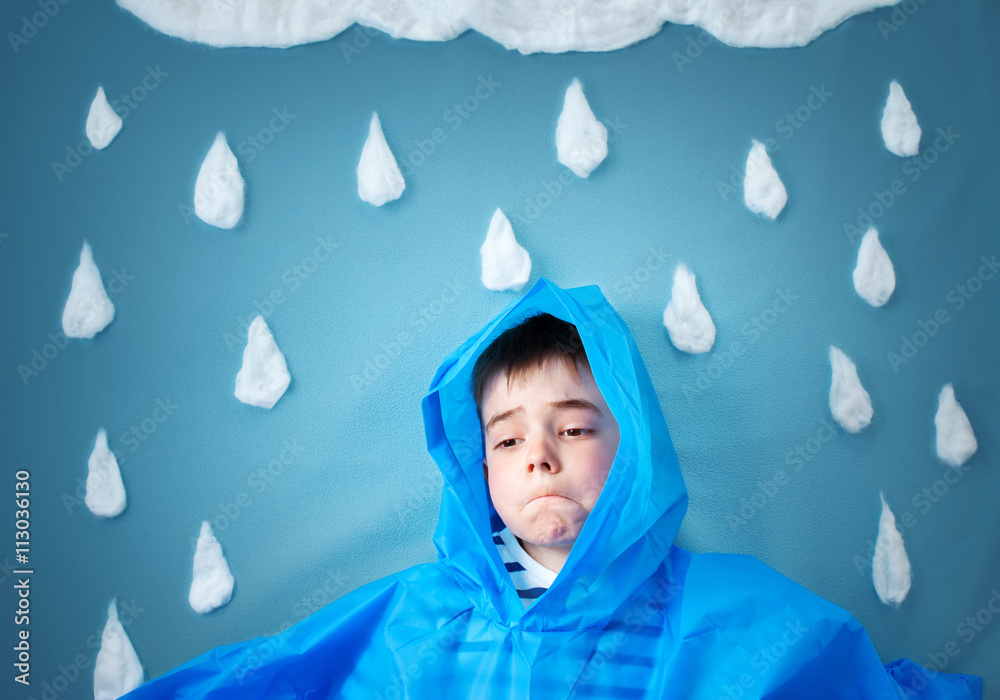 蓝色背景的男孩，穿着水滴形和云朵的外套